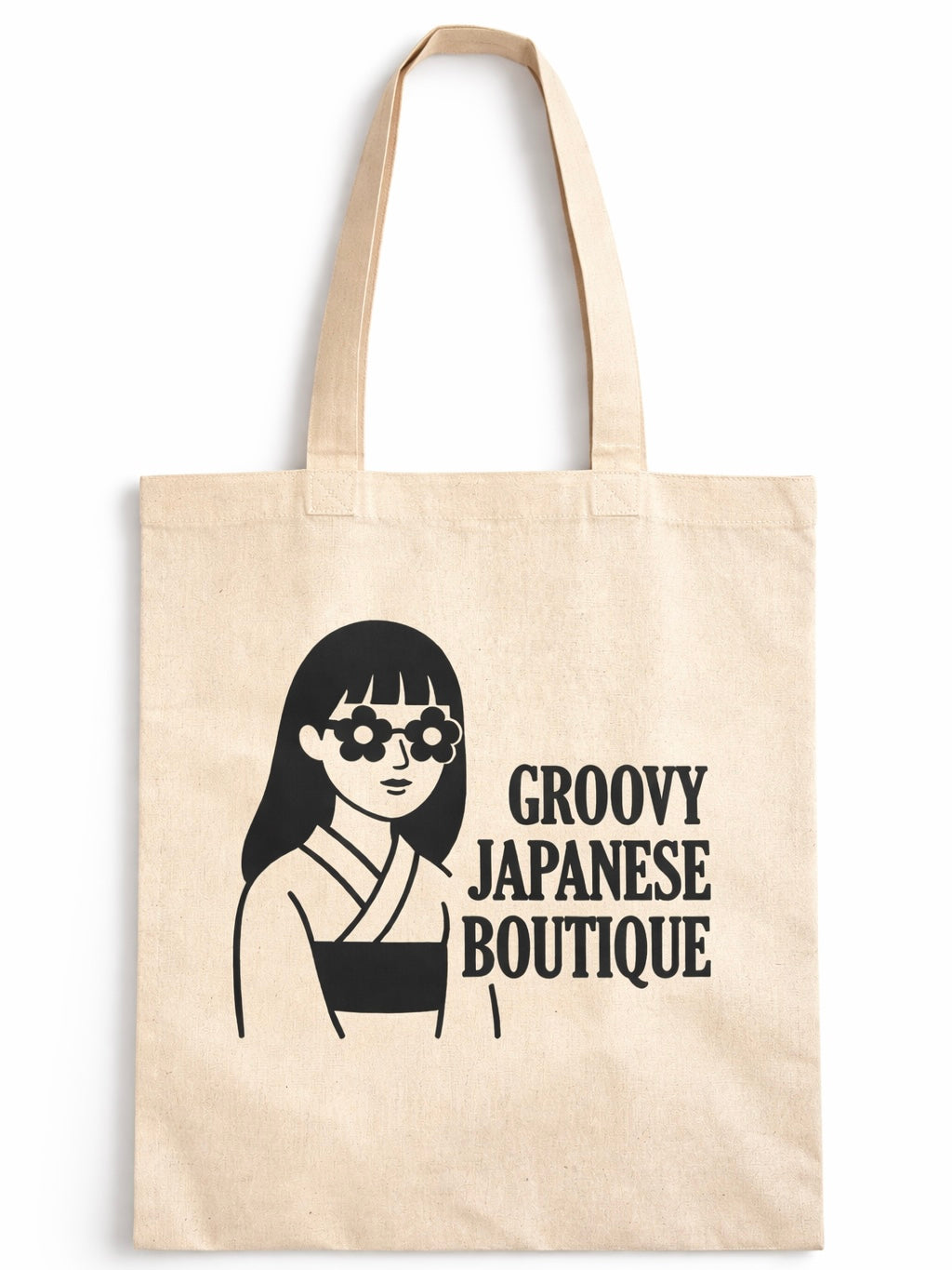 Natural beige cotton canvas tote bag featuring a bold black “Groovy Japanese Boutique” logo with a minimalist illustrated figure, shown worn over the shoulder by a woman in a casual street setting.