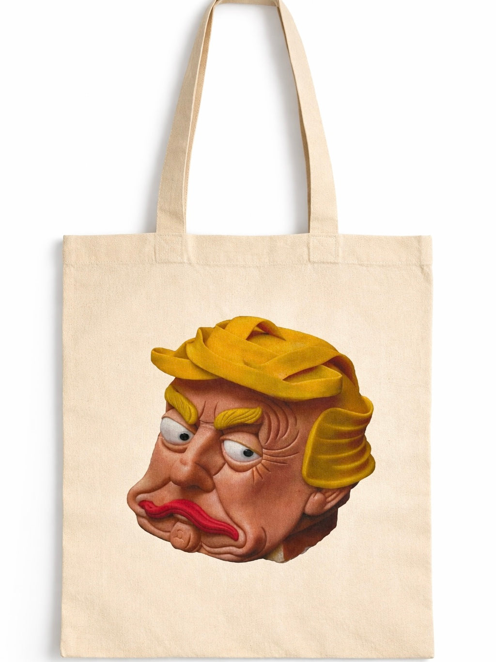 Natural cotton canvas tote bag featuring a bold surreal caricature-style portrait print in warm tones, shown worn over the shoulder by a woman in a casual street setting.